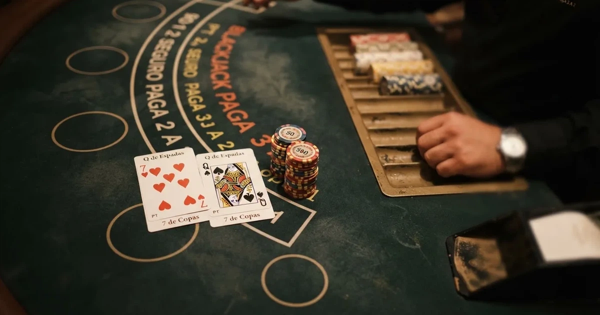Mesa de jogo iluminada com cartas, vista de cima — estratégia de blackjack para portugueses